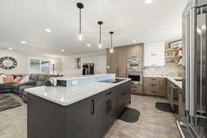 Kitchen with two tone color scheme, stainless steel appliances, a center island, and modern cabinets