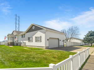 View of property exterior featuring a fenced front yard, driveway, and a garage