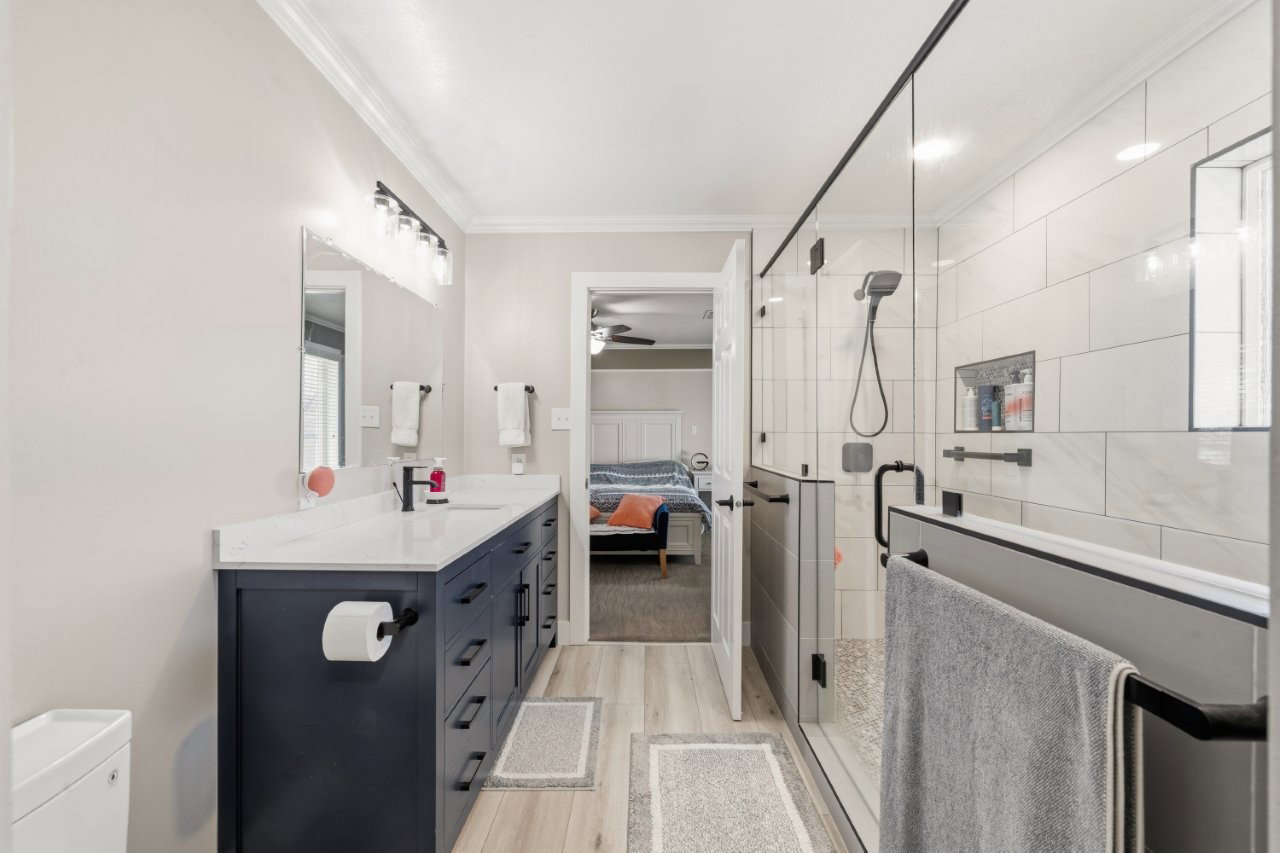 Bathroom featuring ensuite bathroom, vanity, a shower stall, light wood-type flooring