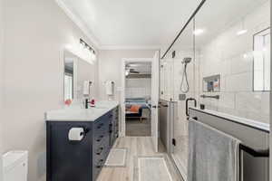Bathroom featuring ensuite bathroom, vanity, a shower stall, light wood-type flooring