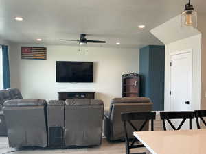 Living area with recessed lighting, light wood-type flooring, a ceiling fan, and a textured ceiling