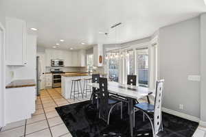 Dining area featuring light tile patterned floors and hanging lights