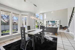 Dining area featuring light tile patterned flooring, rail lighting, and ceiling fan