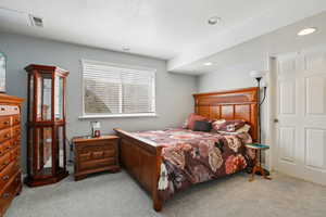 Bedroom with light colored carpet and a textured ceiling