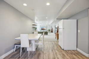 Dining space with light wood-style floors and recessed lighting