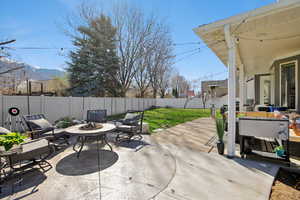 Fenced backyard with a patio area and an outdoor living space with a fire pit