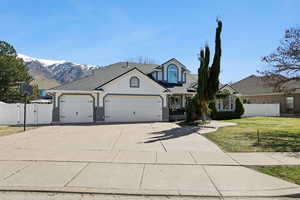 Traditional-style house featuring a gate, concrete driveway, a garage, and stucco siding