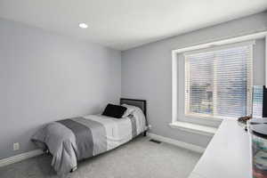 Bedroom with light colored carpet and recessed lighting