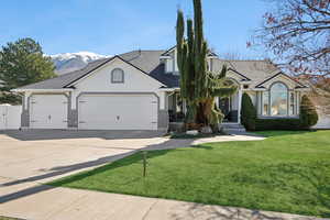 View of front of house featuring brick siding, a front yard, a garage, and stucco siding