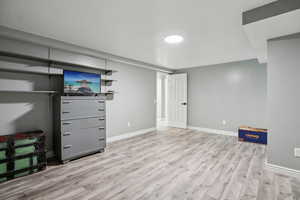 Basement featuring baseboards and light wood-style floors