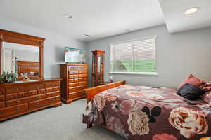 Bedroom with light carpet, recessed lighting, and a textured ceiling