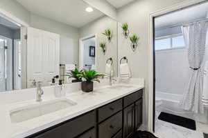Full bathroom featuring double vanity, shower / bathtub combination with curtain, and recessed lighting