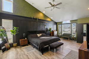 Bedroom featuring light wood-style floors, recessed lighting, wood walls, ceiling fan, and lofted ceiling