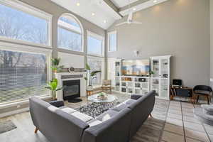 Living room featuring a glass covered fireplace, light wood finished floors, recessed lighting, ceiling fan, and vaulted ceiling