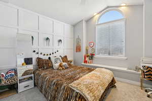 Bedroom featuring light carpet and lofted ceiling