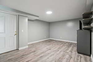 Finished basement featuring light wood-style flooring and baseboards