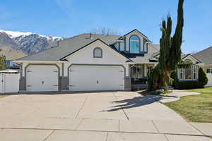 View of front of house with stucco siding, a garage, driveway, brick siding, and a shingled roof