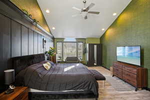 Bedroom featuring recessed lighting, light wood-style flooring, lofted ceiling, ceiling fan, and an accent wall