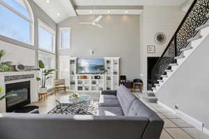 Living room featuring a glass covered fireplace, recessed lighting, ceiling fan, and lofted ceiling