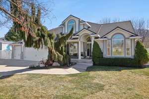 View of front of house featuring a front yard, a shingled roof, stucco siding, concrete driveway, and an attached garage