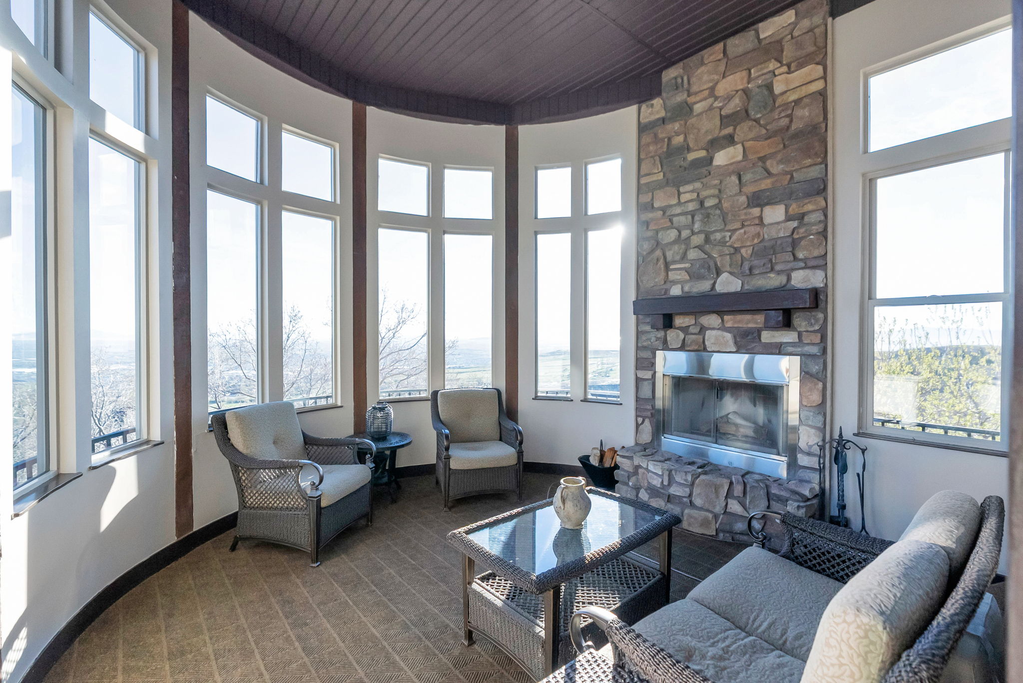 Living area with a fireplace, a high wooden ceiling, healthy amount of natural light, and carpet