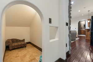 Hallway featuring arched walkways and recessed lighting