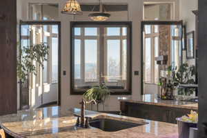Kitchen featuring light stone counters and a sink