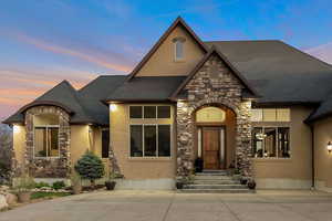 View of front of property with stone siding, stucco siding, and entry steps