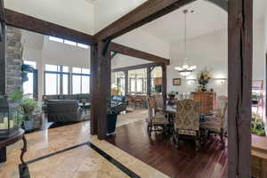 Dining room featuring healthy amount of natural light, inlaid floor details, hanging lights, and a wood stove