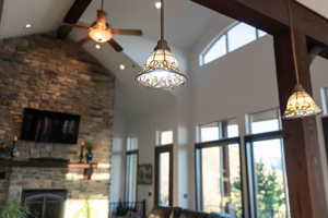 Living room featuring a stone fireplace, a high ceiling, and recessed lighting