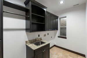 Laundry room with washer hookup, electric dryer hookup, and cabinet space