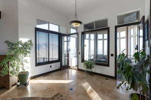 Entryway with baseboards and a high ceiling