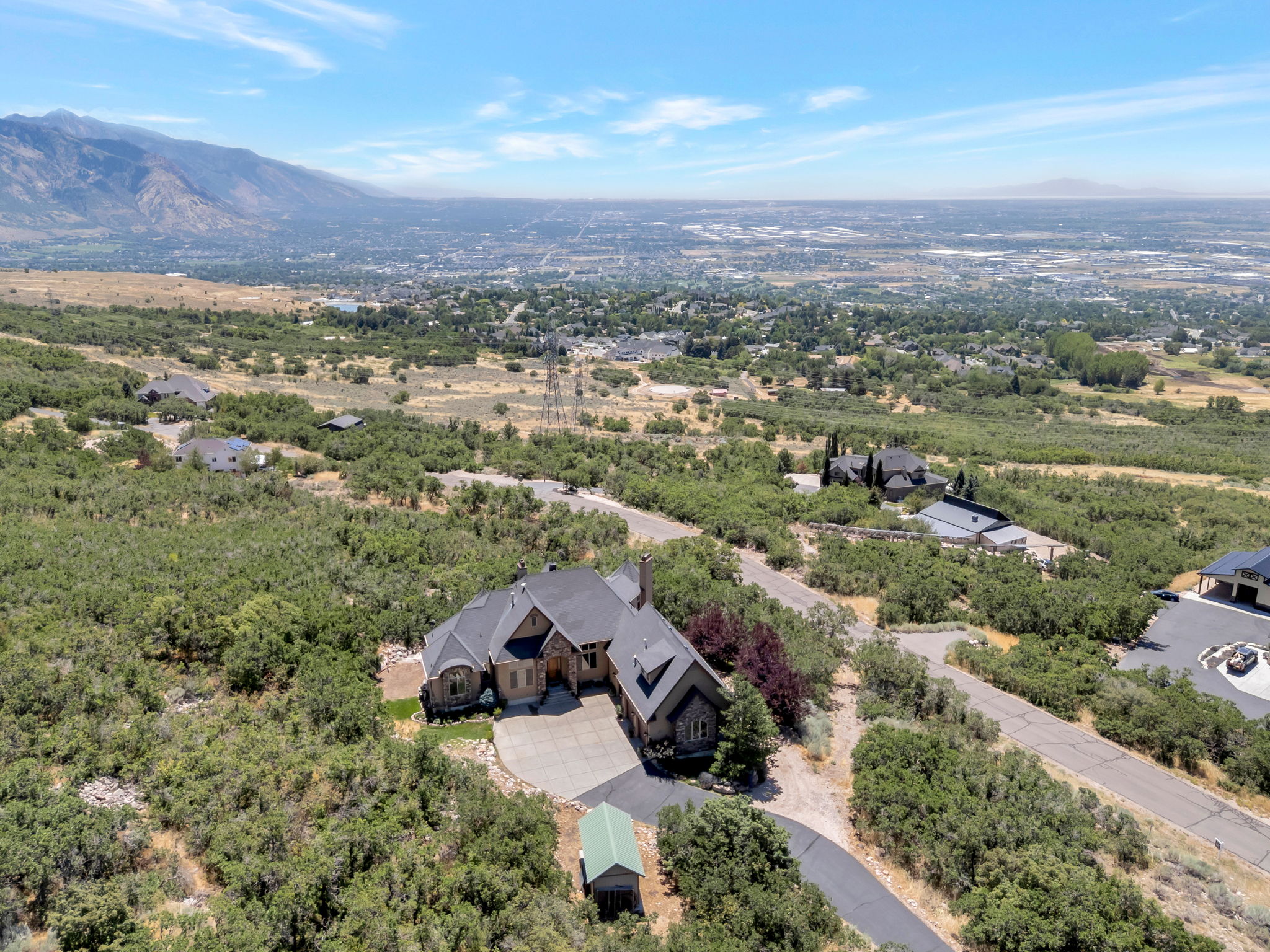 Spacious property featuring a stone and stucco exterior, multiple rooflines, and an attached garage with a paved driveway