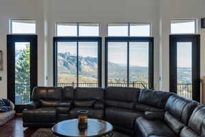 Living area featuring a mountain view, healthy amount of natural light, hardwood / wood-style floors, and a high ceiling