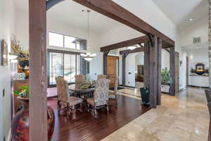 Dining room featuring arched walkways, wood finished floors, lofted ceiling, and hanging lights