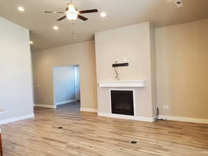 Unfurnished living room with recessed lighting, ceiling fan, light wood-style floors, and a fireplace