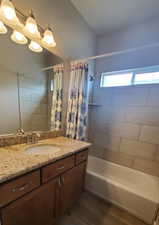 Bathroom featuring vanity, shower / tub combo, and dark wood-style flooring