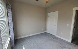 Unfurnished bedroom featuring carpet flooring and ceiling fan