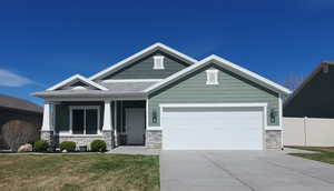 Craftsman house with stone siding, a porch, an attached garage, and driveway