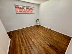 Unfurnished room with hardwood / wood-style flooring and baseboards