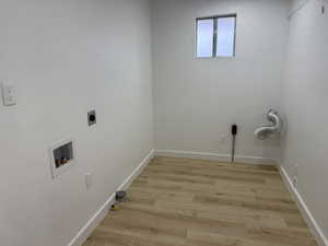 Laundry area with light wood-type flooring, electric dryer hookup, and washer hookup