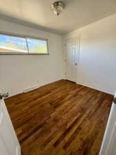 Spare room with dark wood finished floors and baseboards