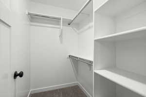 Walk in closet featuring dark carpet