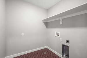 Laundry area featuring hookup for an electric dryer, hookup for a washing machine, and dark carpet