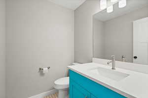 Half bath featuring vanity and toilet