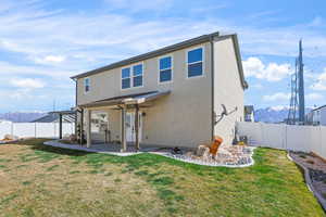 Back of house featuring a mountain view, stucco siding, a fenced backyard, and a patio