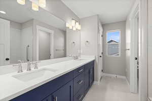 Bathroom featuring double vanity and light tile patterned flooring