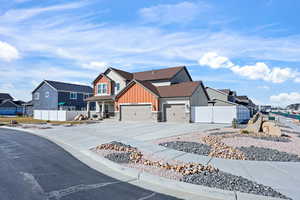View of front of house with a residential view, board and batten siding, an attached garage, a porch, and a gate