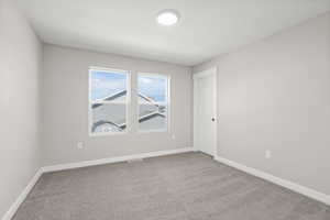 Empty room with baseboards and light colored carpet