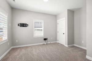 Spare room featuring baseboards and light colored carpet